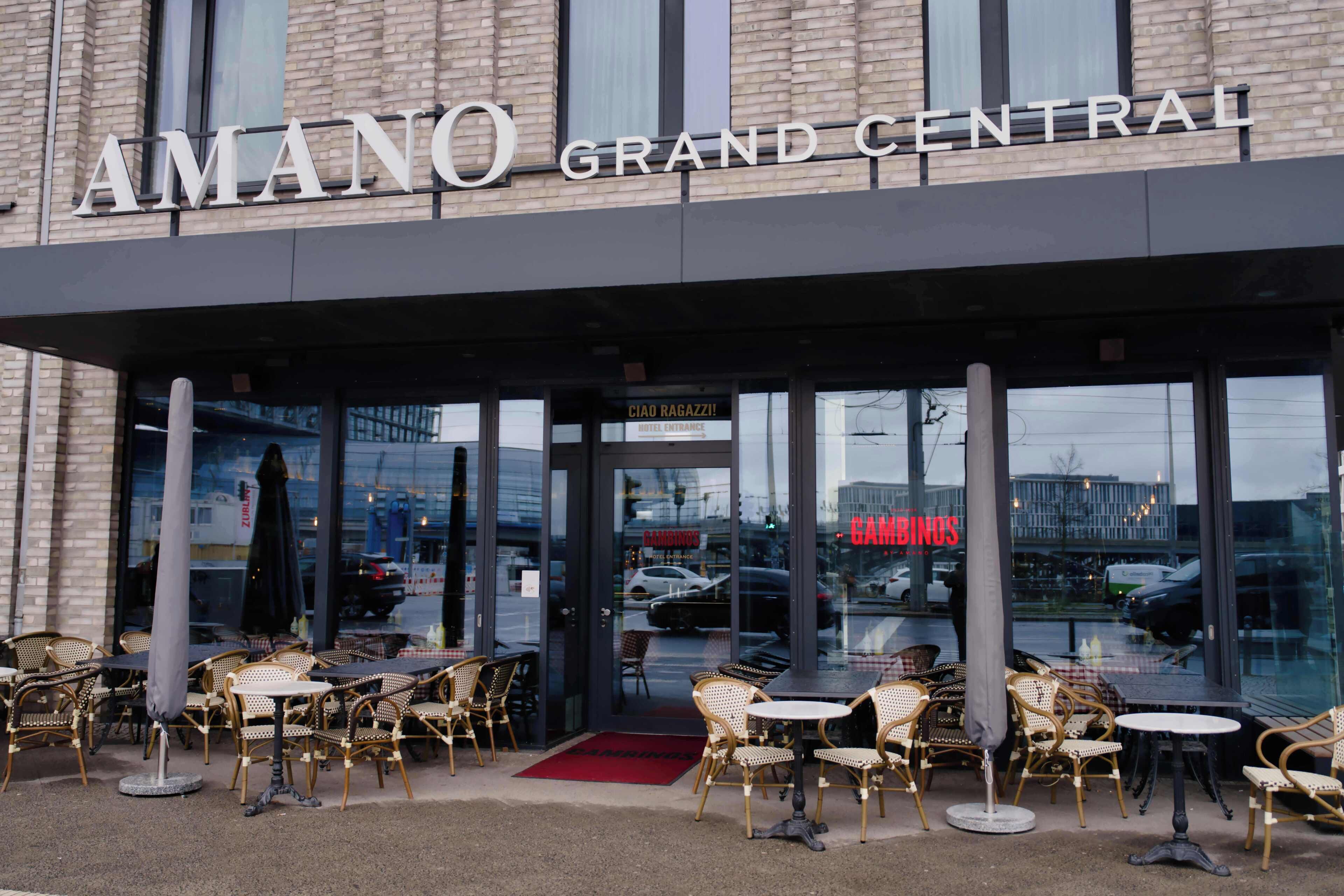 L’entrée d’un hôtel avec un espace extérieur aménagé et une enseigne bien visible indiquant « AMANO GRAND CENTRAL ».