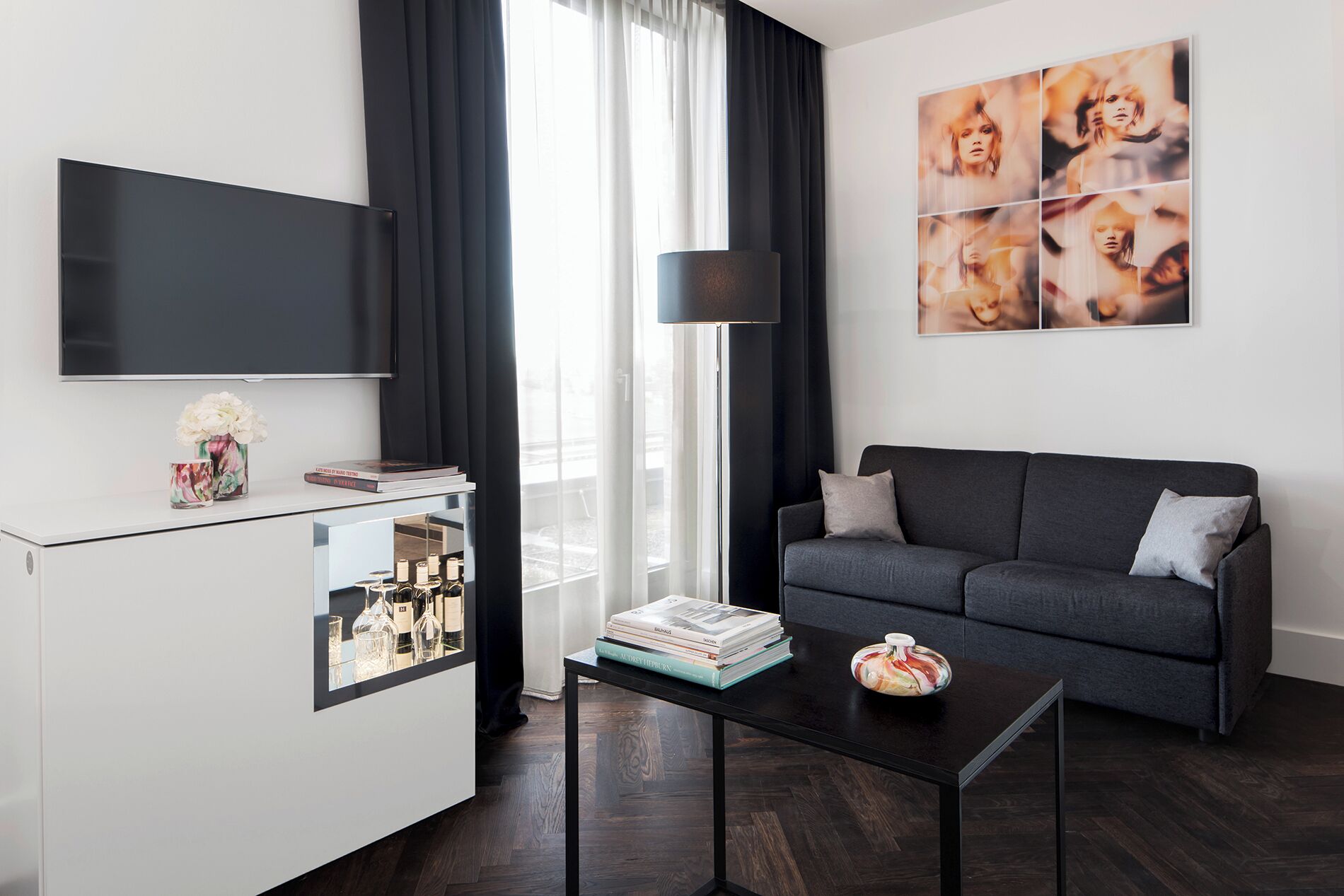 A modern living room with a flat-screen TV, a sofa, a coffee table, and a bookshelf.