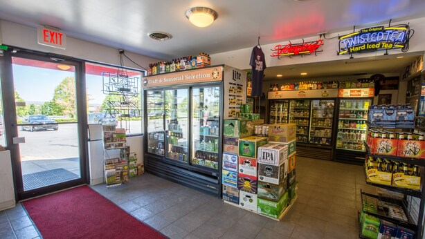 A store with a red carpet, a craft and seasonal selection fridge, and a Twisted Tea sign. - Nittany Budget Motel (State College)