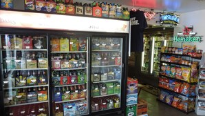 A convenience store with refrigerated sections for beverages and snacks. - Nittany Budget Motel (State College)