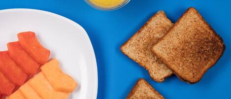 A plate with slices of toast and carrot sticks on a blue background.