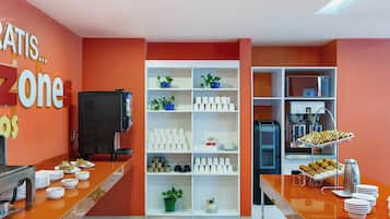 A buffet area with a variety of food items, a coffee station, and a refrigerator.