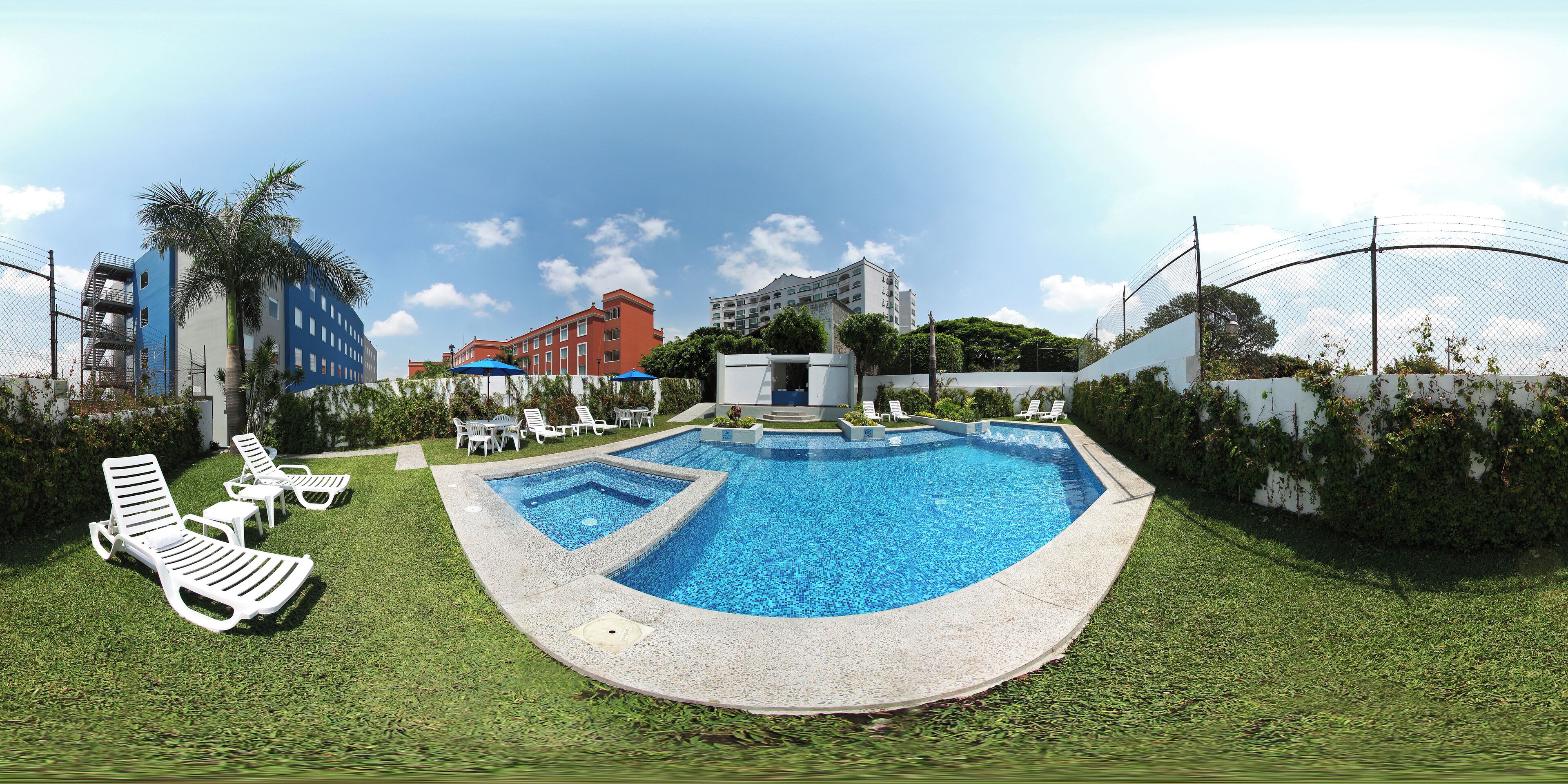 A swimming pool with lounge chairs, a small pool house, and surrounding greenery.