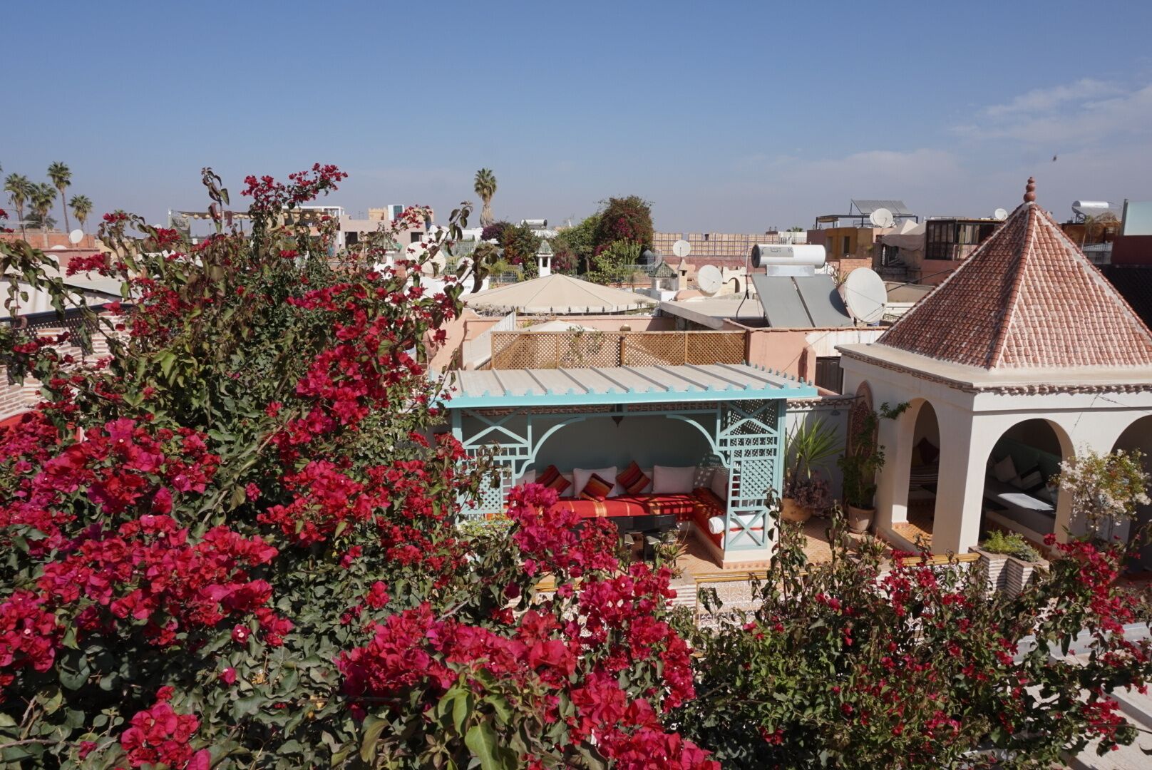 A rooftop garden with a gazebo, a small pavilion, and a traditional building with a conical roof.