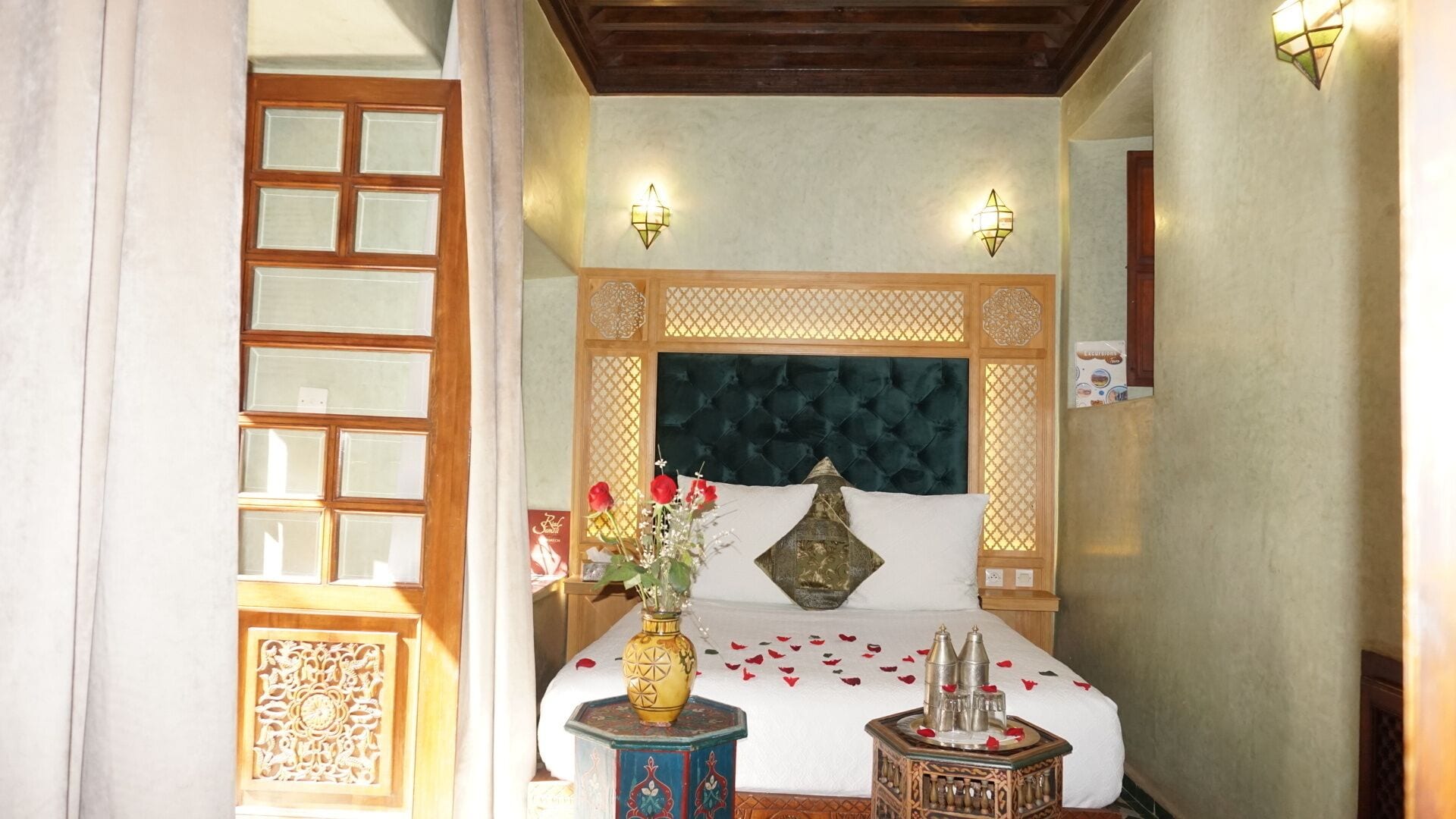 Ein Schlafzimmer mit einem Bett, einer Zierdeovase und einem kleinen Tisch mit Tablett.