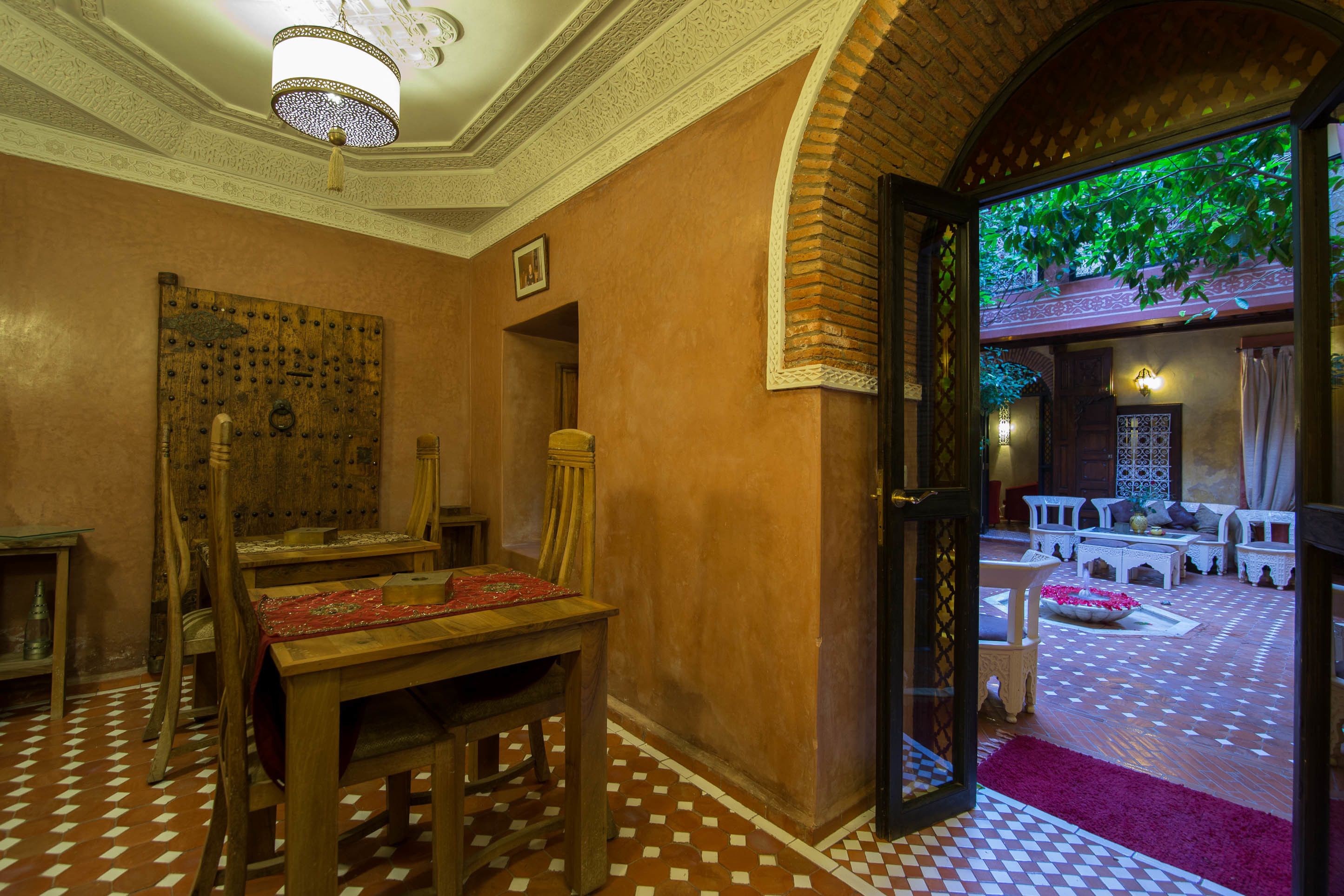 A traditional room with a wooden table, chairs, and a patterned floor.