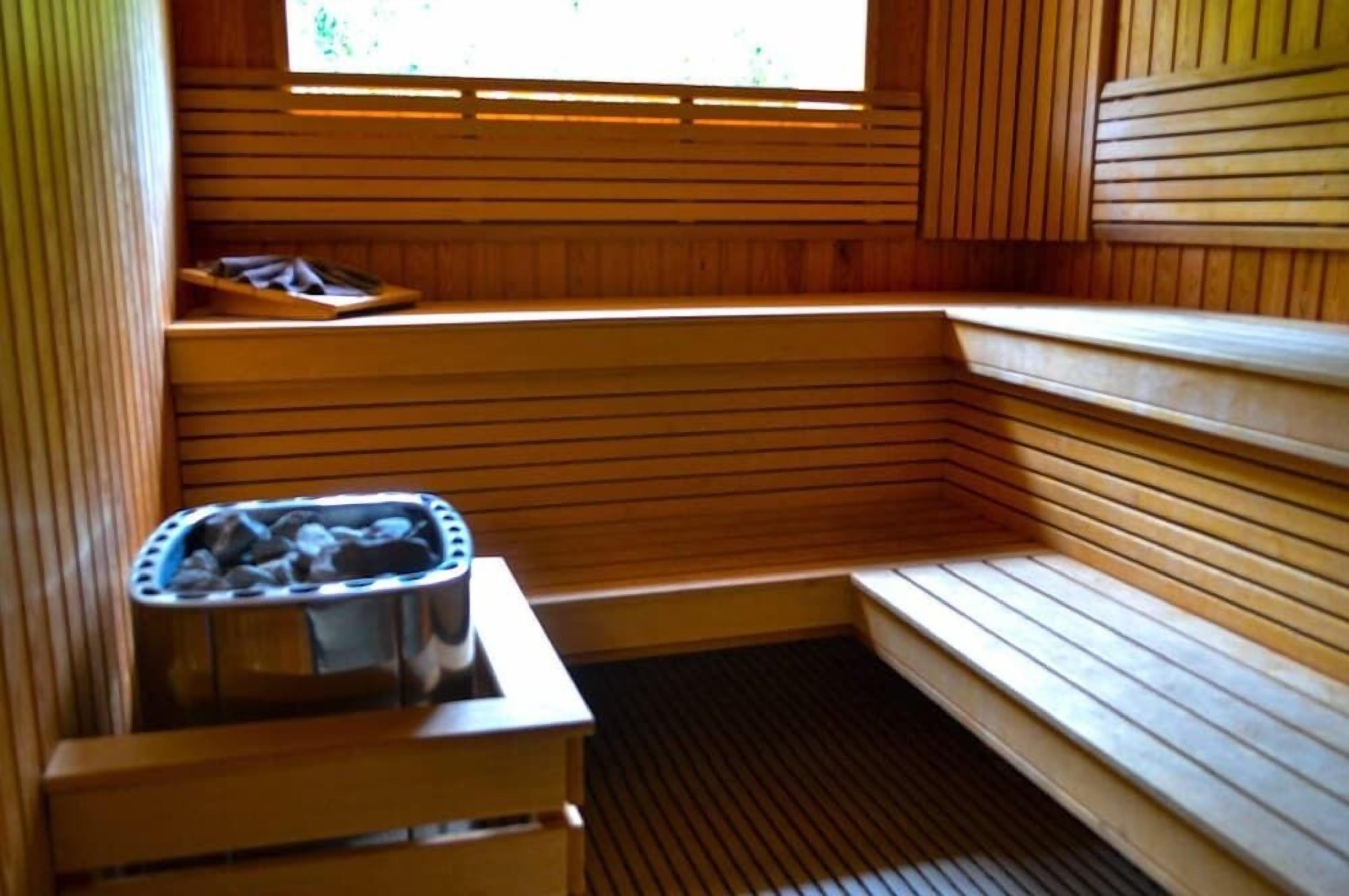 A sauna with wooden benches and a hot tub.