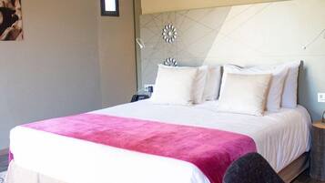 Habitación de hotel con una cama grande, una mesita de noche y un adorno en la pared.