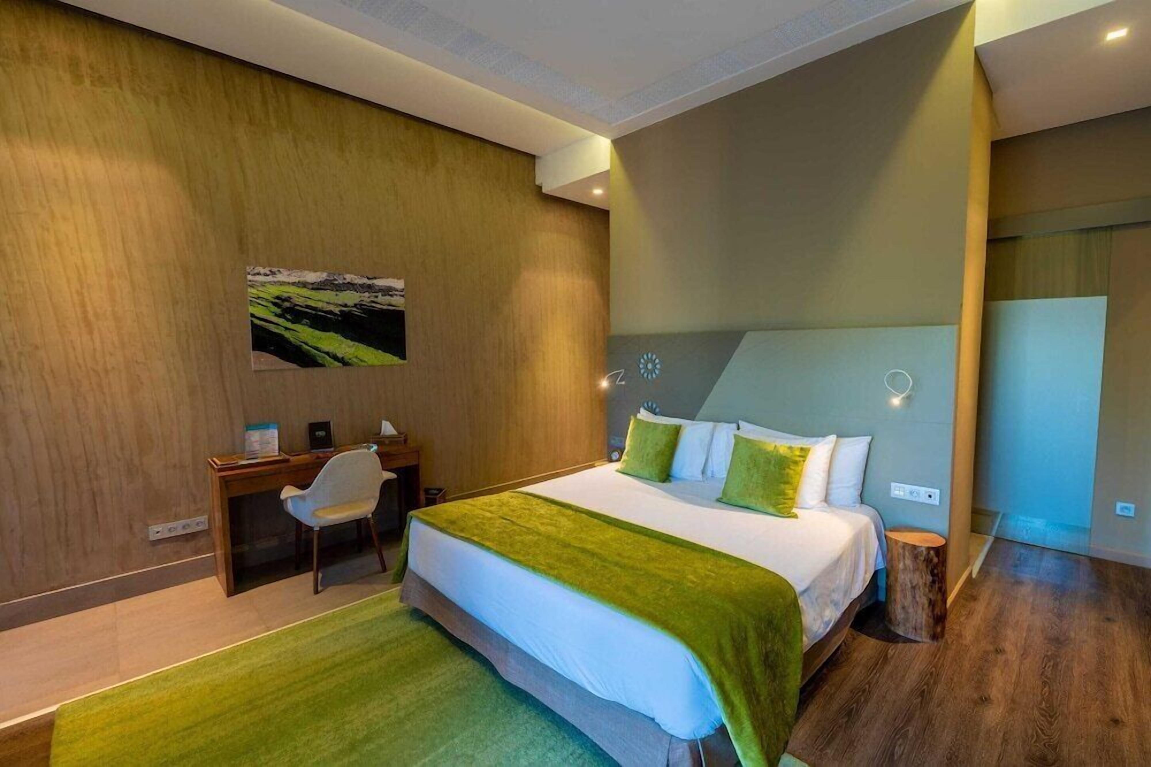 Habitación de hotel moderna con una cama grande, un escritorio y una silla.