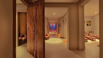 A hallway with a wooden partition, a spa area with loungers, and a view of a stage with lights.
