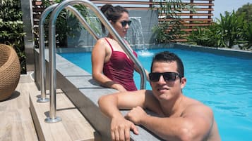 Un área de piscina con una escalera metálica y una cubierta de madera.
