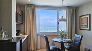 A dining area with a view of the sea, a table with chairs, a potted plant, and a framed picture on the wall. - Hotel Perla Spondylus (Manta)