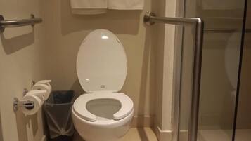 A modern bathroom with a white toilet, a glass shower enclosure, and a towel rack with 'DiverXO Hotel' branding.