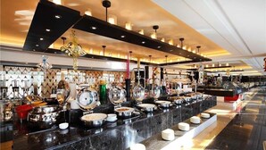 En buffé med flera serveringsstationer, en bänkskiva i marmor och belysning ovanför.