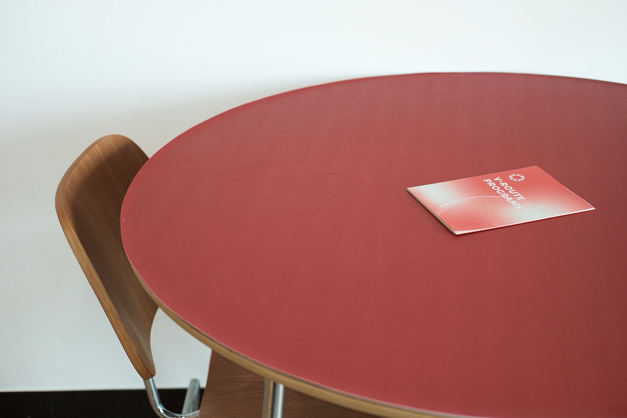 A round table with a red surface and a brochure titled "K-Route Programs" on it.