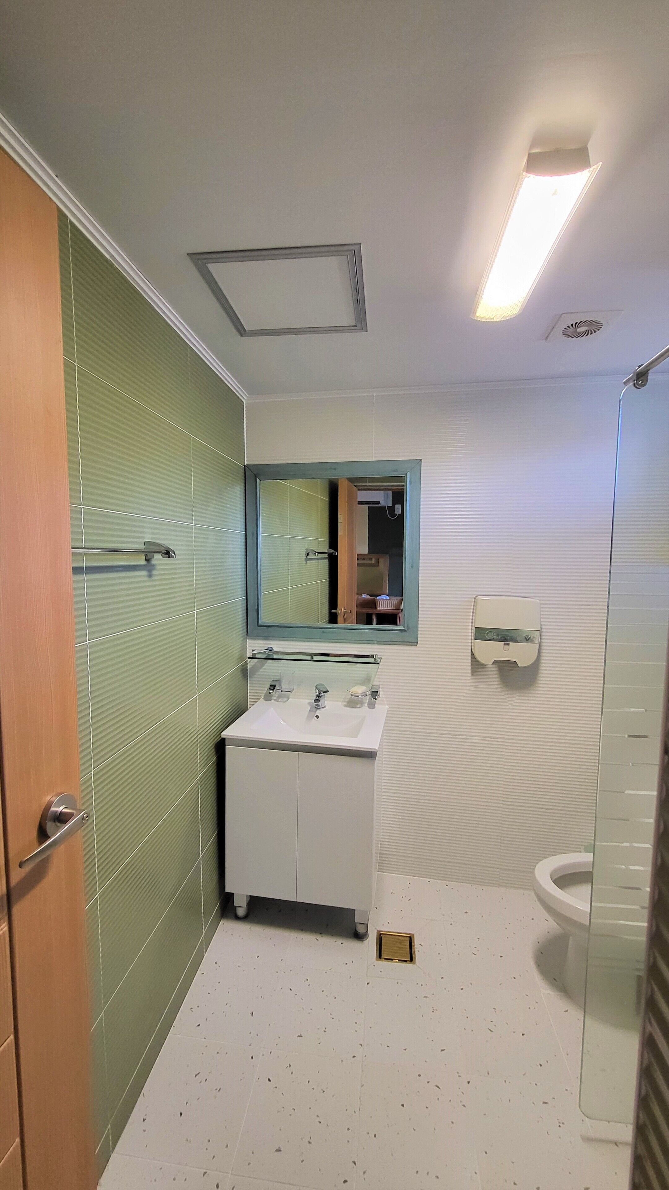 A bathroom with a white sink, a mirror, and a toilet.