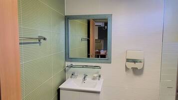 A bathroom with a white sink, a mirror, and a toilet.