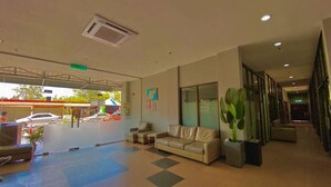A spacious lobby with a checkered floor, a leather sofa, a potted plant, and a staircase leading to upper floors. - Langgura Baron Resort (Langkawi)