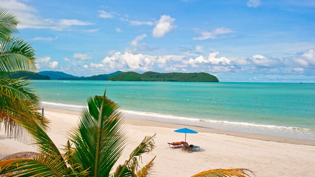 A beach with clear turquoise water, a sandy shore, and a distant island. - Langgura Baron Resort (Langkawi)