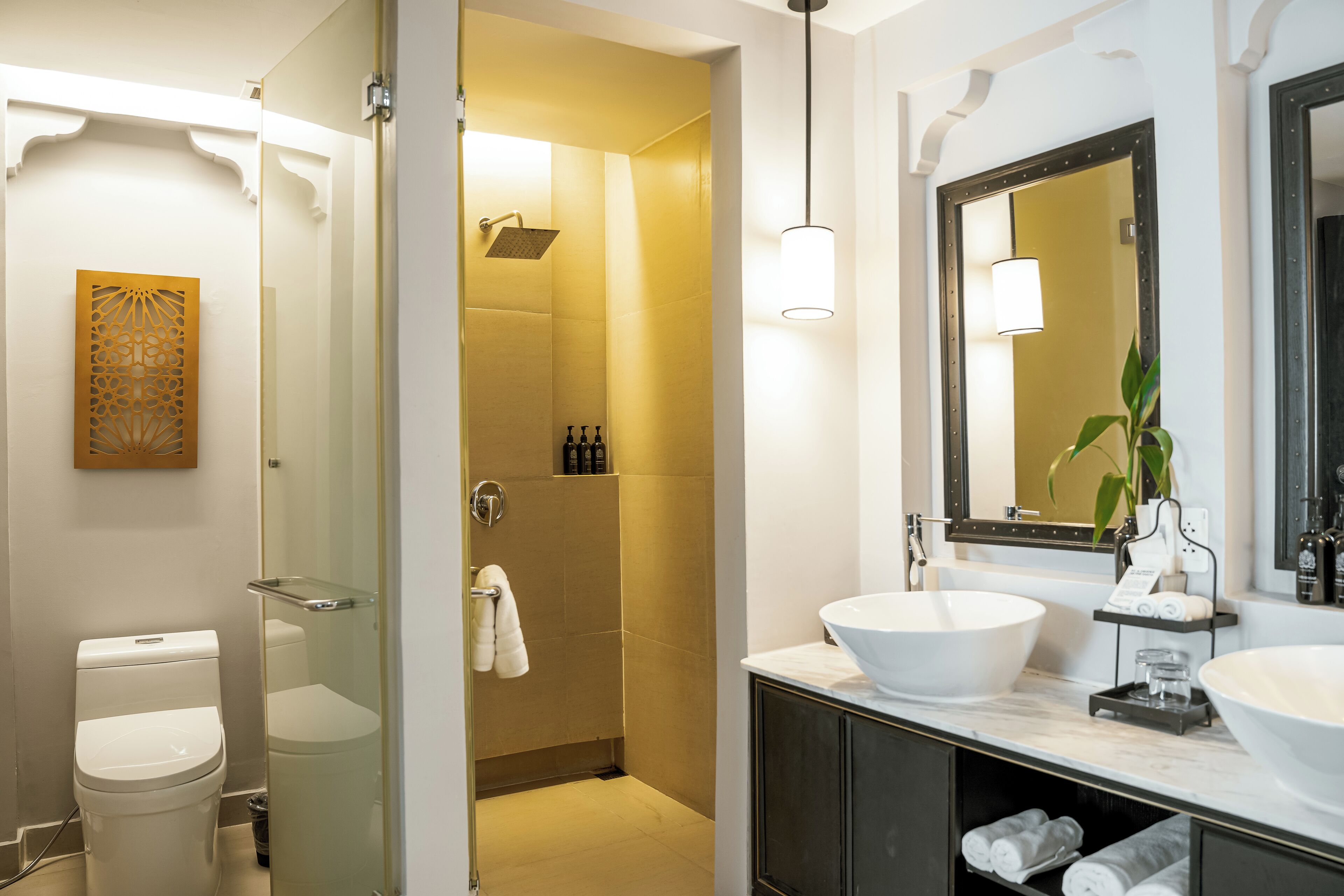 A modern bathroom with a glass-enclosed shower, a large white sink, and a mirror with a dark frame.