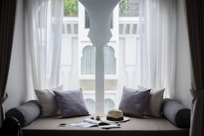 Ein Zimmer mit Fensterbank, mit Hut, Büchern und einem Smartphone.