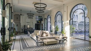 A spacious lobby with a modern sofa, armchairs, and a patterned floor. - Sarai and Wander (Siem Reap)