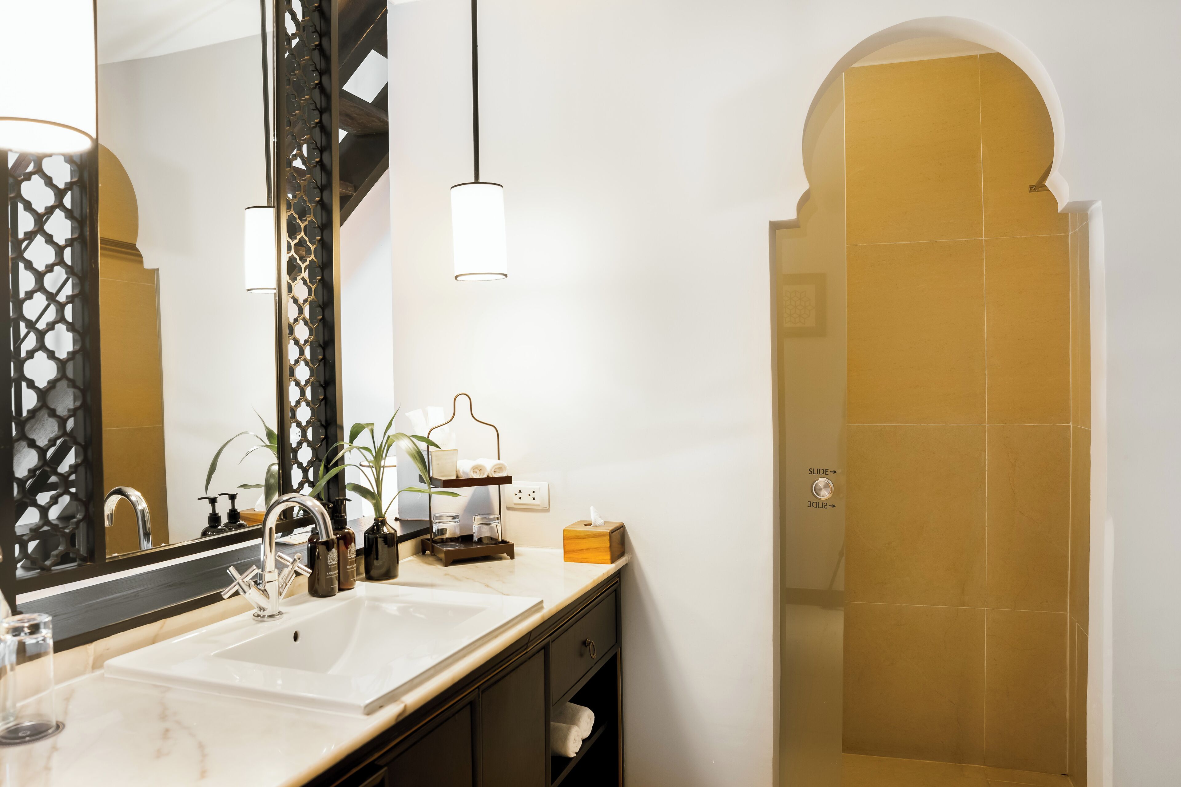 A bathroom with a large mirror, a sink, and a shower area.