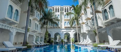 Una piscina al aire libre, tumbonas