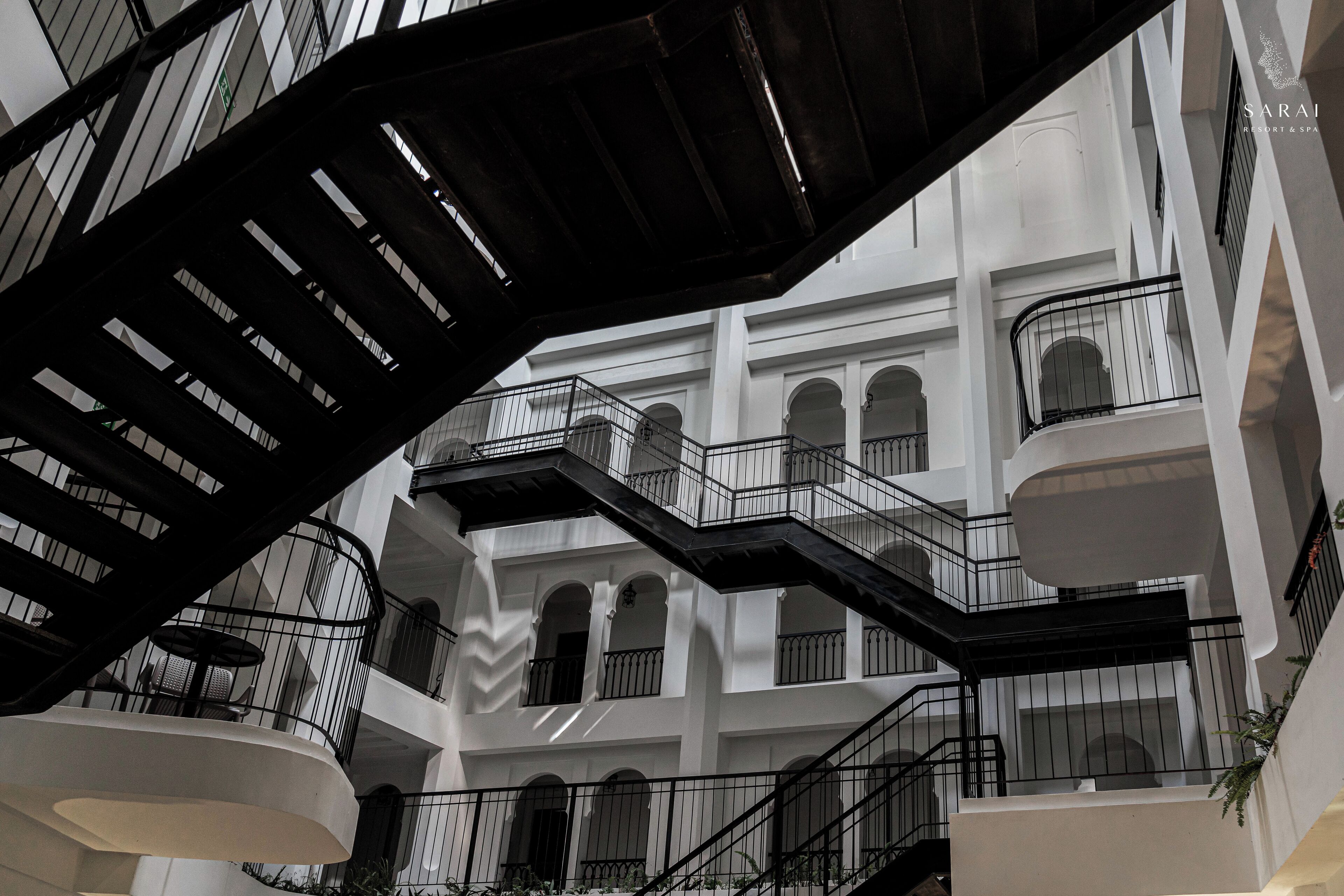A multi-level atrium with a central staircase, balconies, and arched windows.