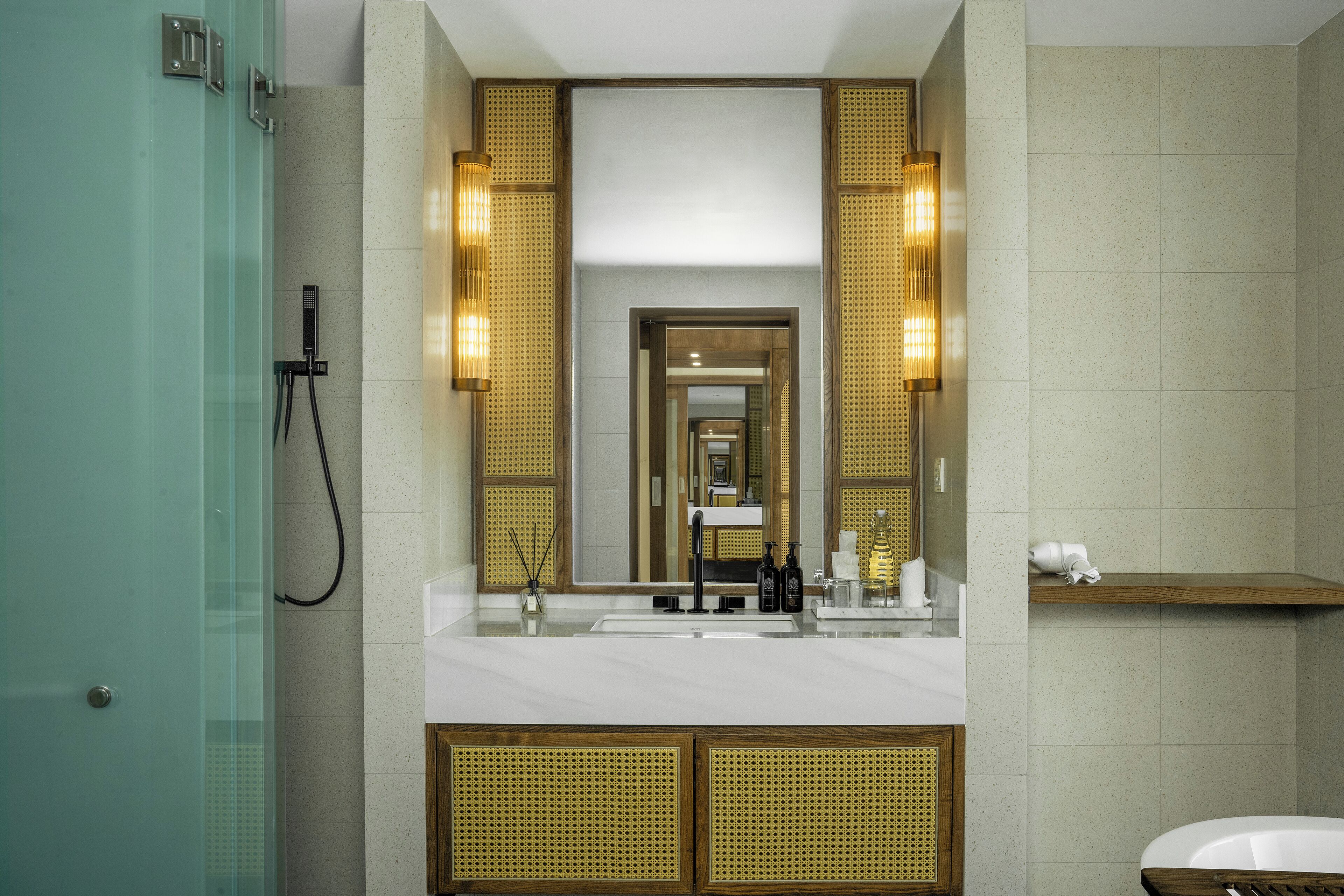 Un baño moderno con cabina de ducha de vidrio, un espejo grande y un tocador con lavabo y encimera.