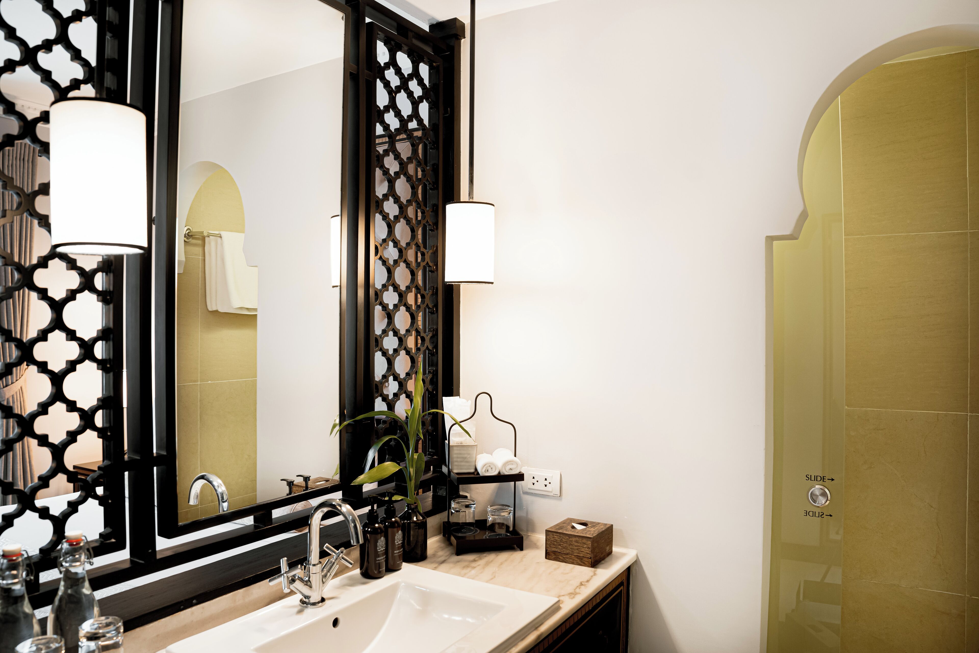 A modern bathroom with a large mirror, a sink, and a towel rack.