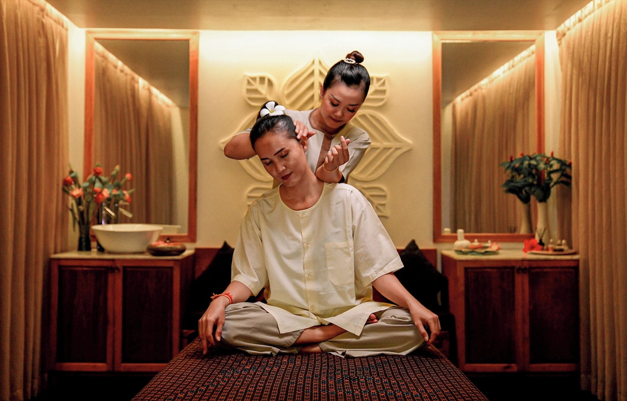 A room with a massage table, a mirror, and a decorative wall.