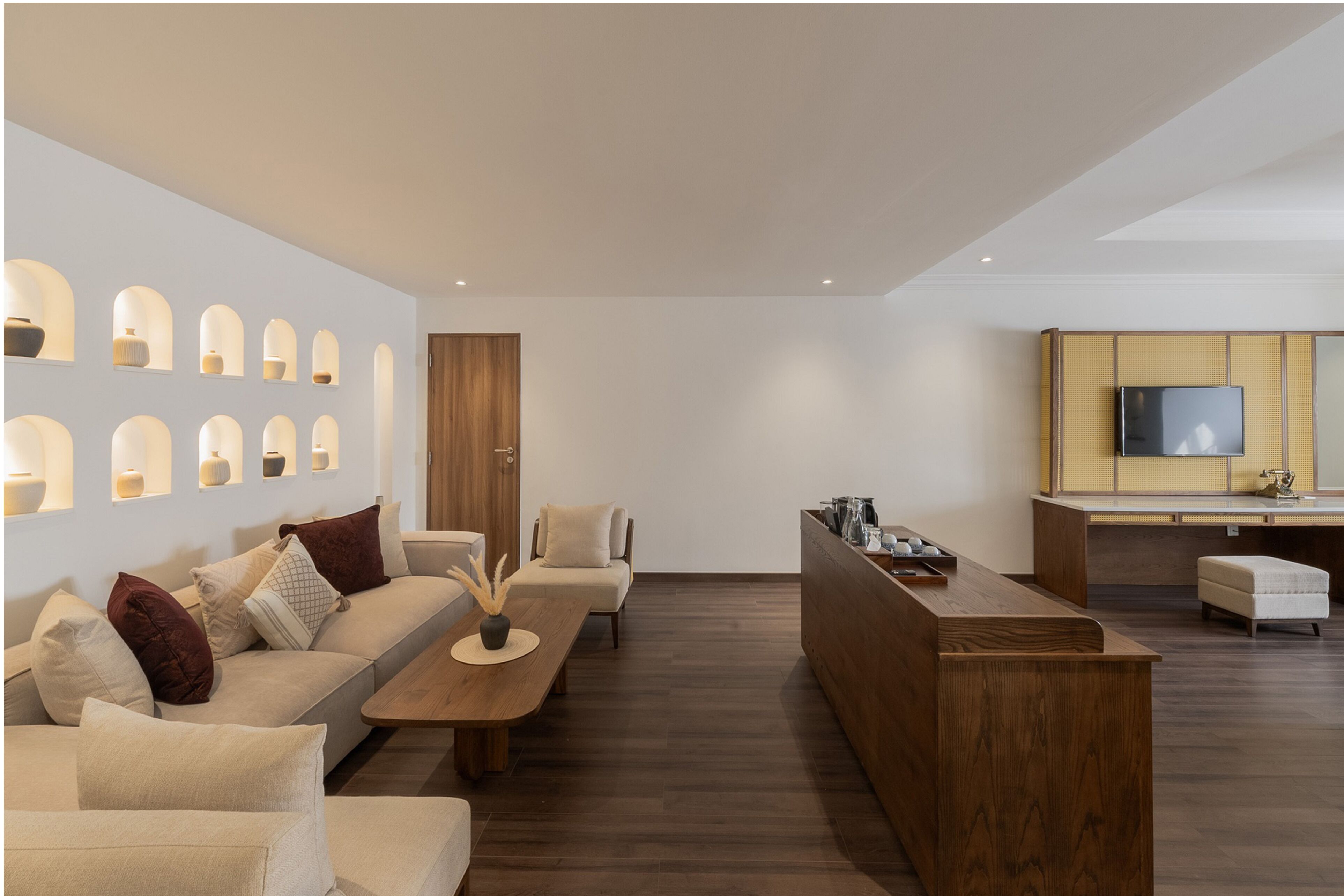 A modern living room with a sofa, coffee table, and a wooden bar area.