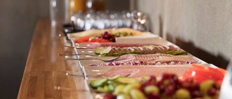 A buffet table with various food items and utensils.