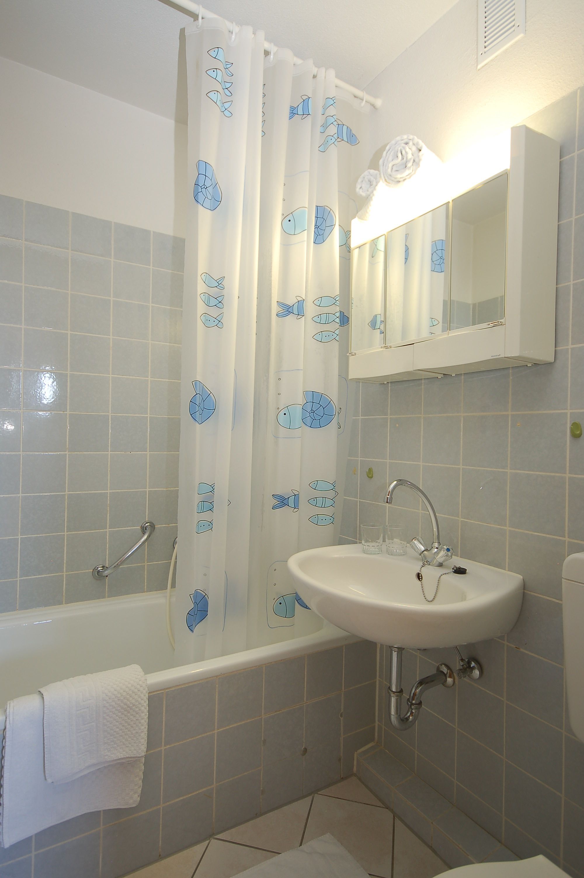 Een badkamer met een bad, een wastafel en een spiegel.