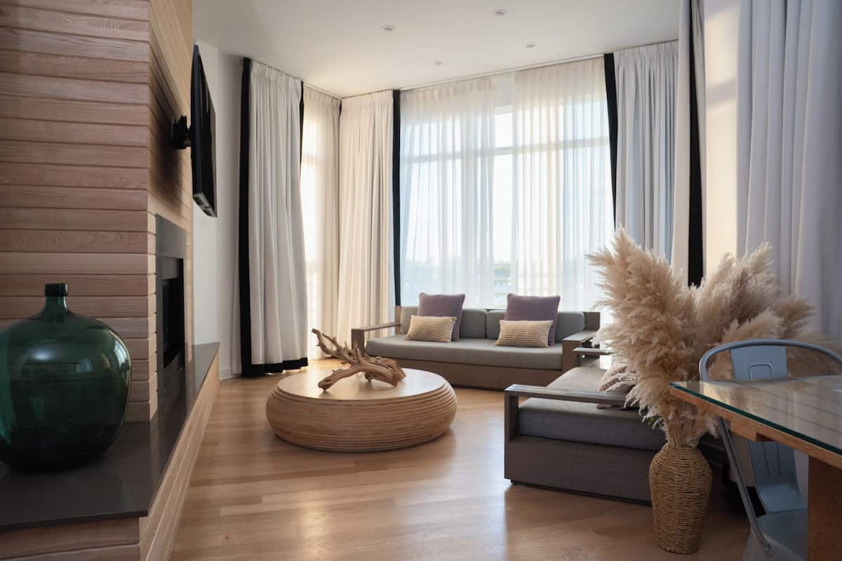Ein modernes Wohnzimmer mit einer Couch, einem Couchtisch und einem an der Wand montierten Fernseher.