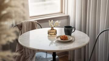 Una mesa redonda con un florero y una taza.