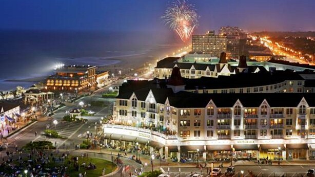 A waterfront hotel with a prominent building featuring a curved facade, multiple stories, and a balcony area. - Bungalow Hotel (Long Branch)