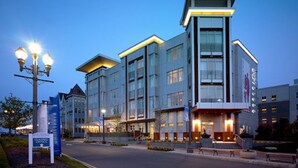 A modern hotel with a prominent entrance, multiple floors, and a well-lit facade. - Bungalow Hotel (Long Branch)