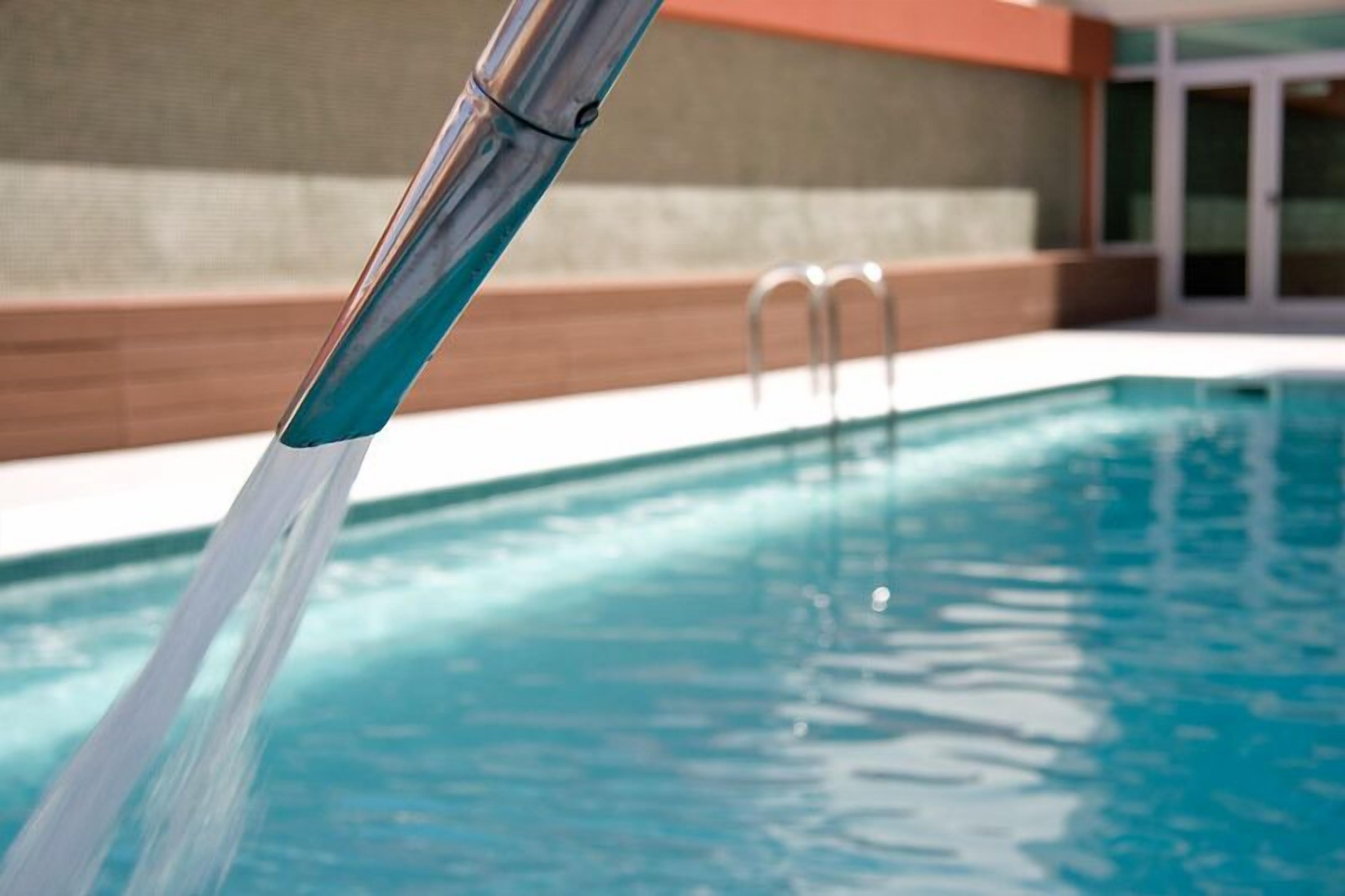 A swimming pool with clear water and a metal ladder.