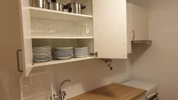 Una cocina con armarios blancos, encimera de madera, un fregadero y una estufa.