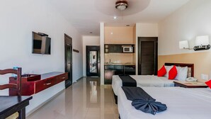 A hotel room with a desk, two beds, a TV, a microwave, and a kitchenette. - Hotel Siglo 21 Merida (Mérida)