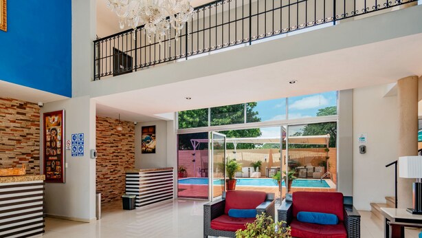 A spacious lobby with a pool area, wicker furniture, and a modern design. - Hotel Siglo 21 Merida (Mérida)