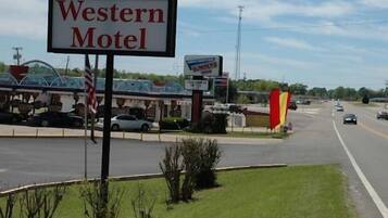 A Western Motel sign with a Burger King and a gas station in the background.