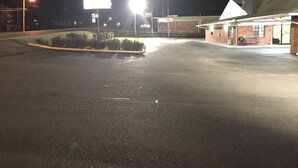 A parking lot with a building that has a green roof and a signboard. - Western Motel - Prentiss (Prentiss)
