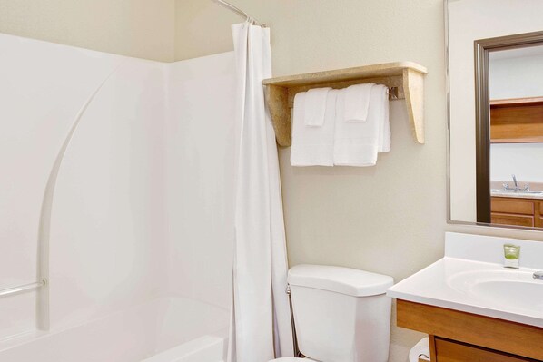 Une salle de bain avec douche, toilettes et lavabo.