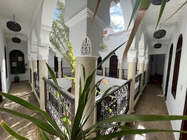 Un interior espacioso con techos altos, arcos y una columna central con una planta.