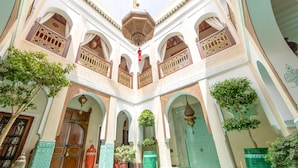 A courtyard with arches, tiled walls, and hanging lanterns. - Riad Hikaya (Marrakech)