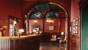 A reception area with a wooden reception desk, two chairs, a chandelier, and framed pictures on the wall. - Hotel St. Michael, BW Premier Collection (Prescott)