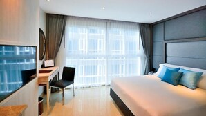 Una habitación de hotel moderna con una cama grande, un escritorio y un televisor.